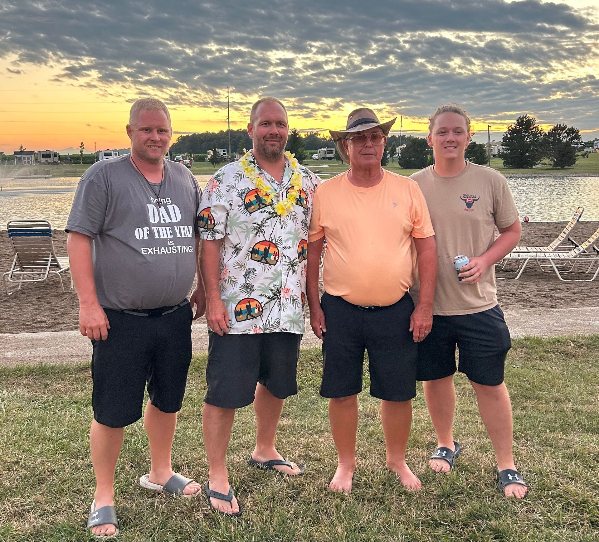 A group of men are posing for a picture in front of a body of water. | Chickasaw Garage