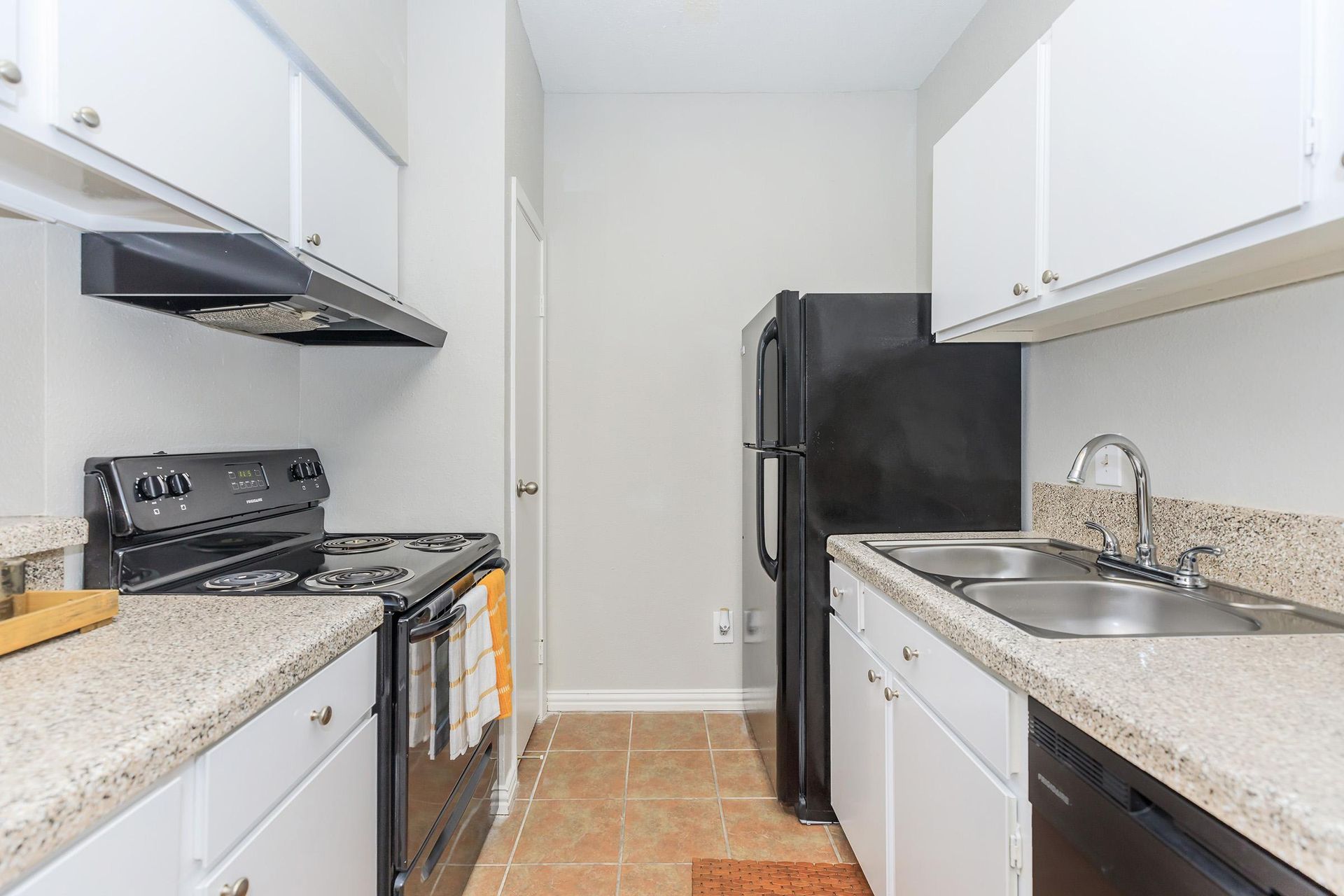 A kitchen with white cabinets and a black refrigerator at Serena Apartment Homes.