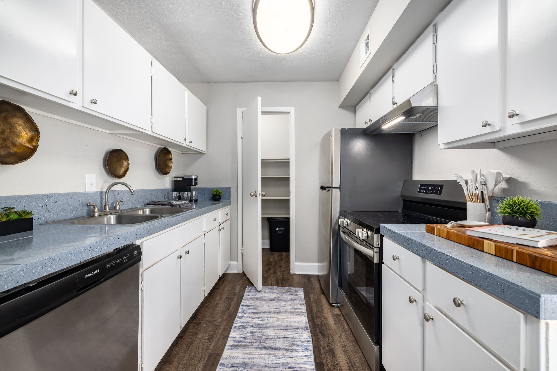 A kitchen with white cabinets and a black refrigerator at Serena Apartment Homes.