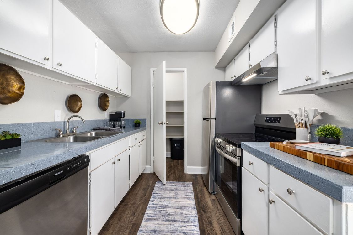 A kitchen with white cabinets and a black refrigerator at Serena Apartment Homes.