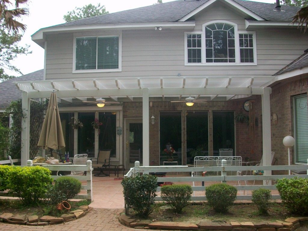 A house with a pergola and a fence in front of it in Katy, TX.