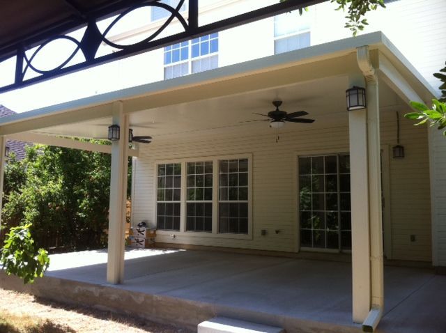 A white house with a covered patio and a ceiling fan in Hutto, TX.