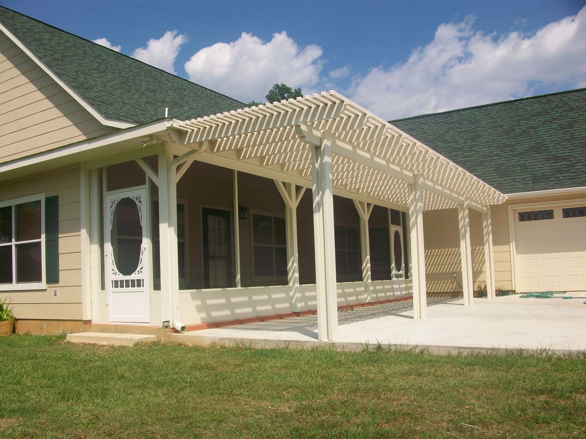 A house with a screened in porch and a pergola built in Cypress, TX.