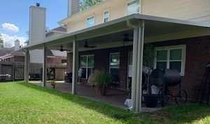 Covered patio in Austin with stone columns and gutters.