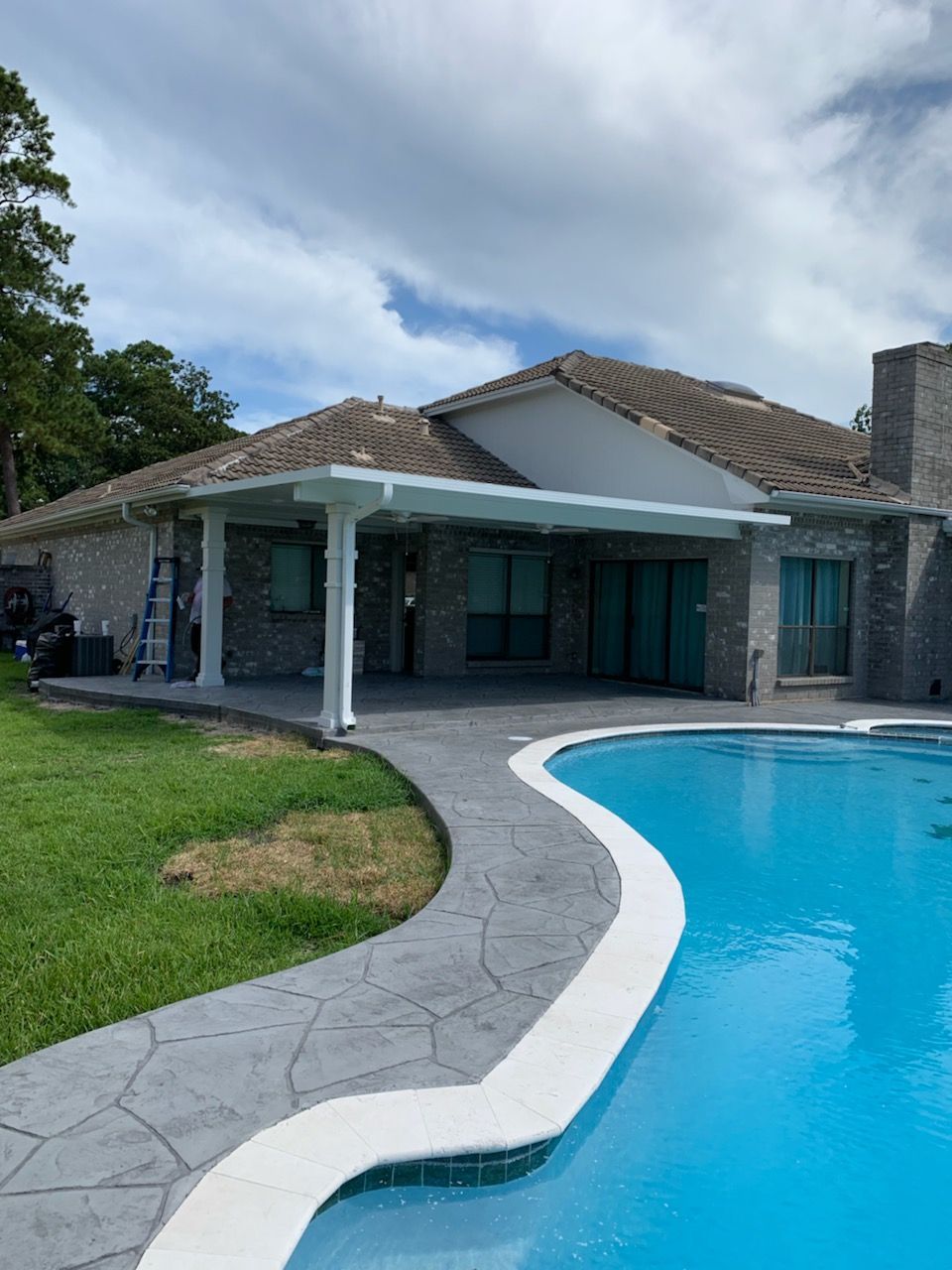 Houston patio builders assembling durable aluminum frame patio extension and roof.