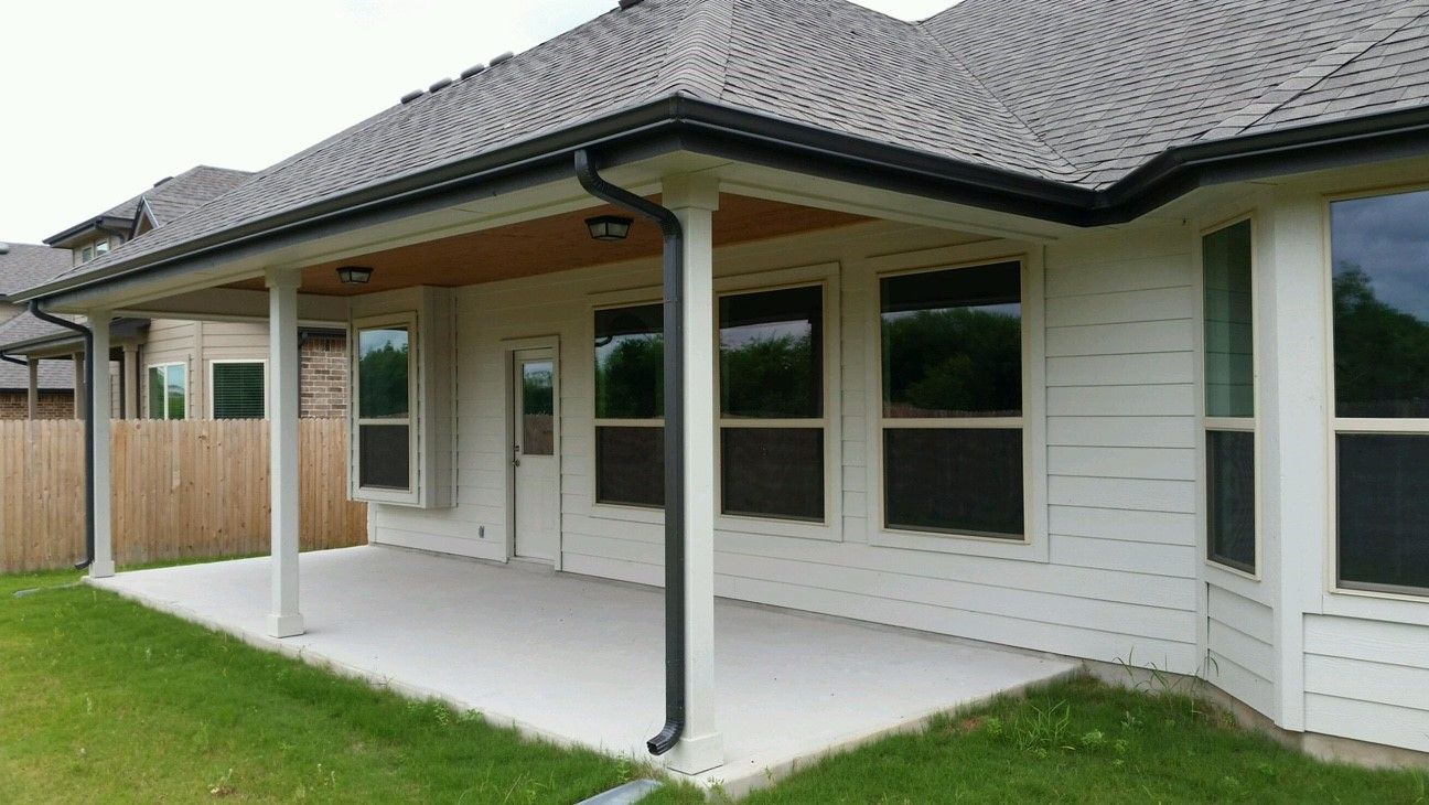 Durable metal patio cover with roof shingles for enhanced weather protection and a polished outdoor aesthetic.