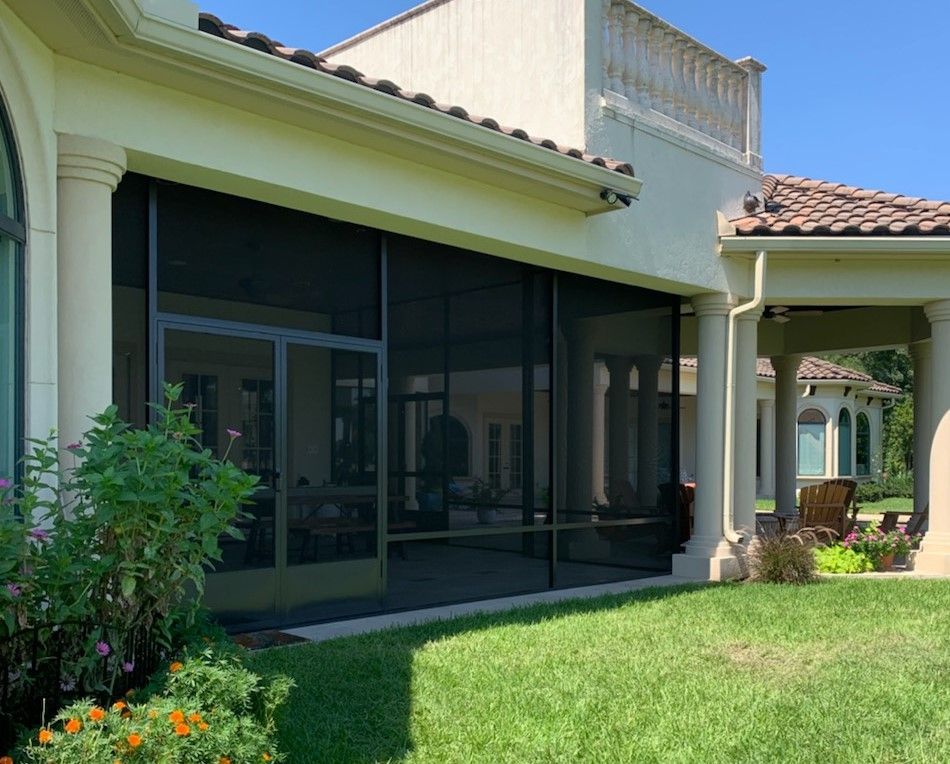 High-end patio cover with screen walls and a set of double screen doors built in Houston, TX.