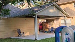 Houston covered patio with roofing shingles build on the side of a garage.
