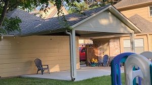 A house with a covered patio and chairs in front of it in Del Valle, TX..