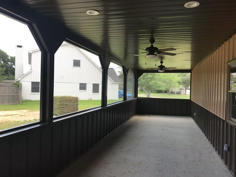 A covered patio with screened walls, transforming a concrete slab into a comfortable outdoor room.
