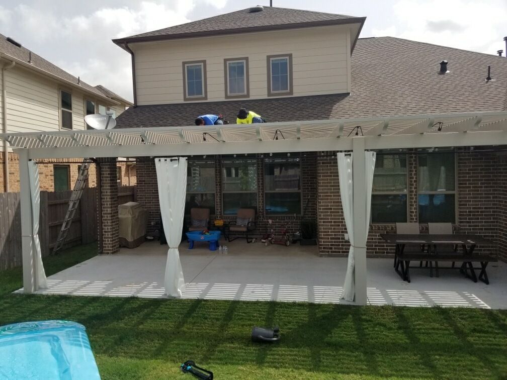 The backyard of a house with a patio and a canopy.