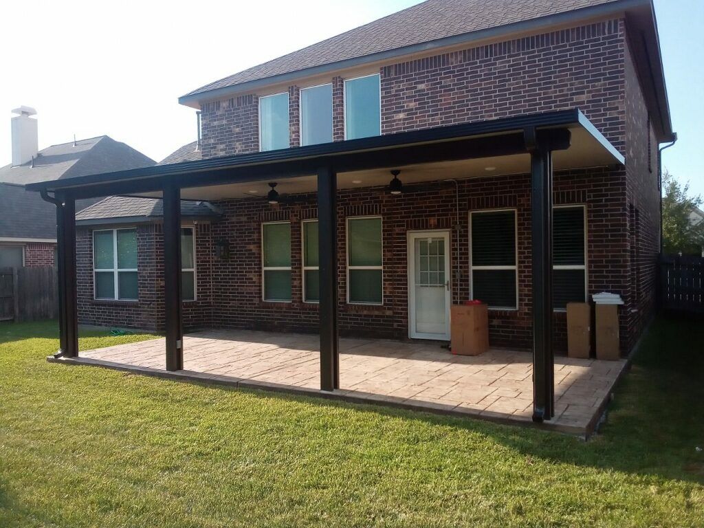 a large brick house with a large covered patio in front of it .