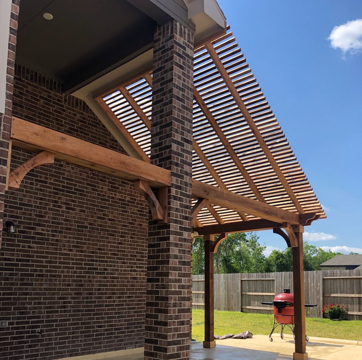 a brick building with a wooden pergola over it