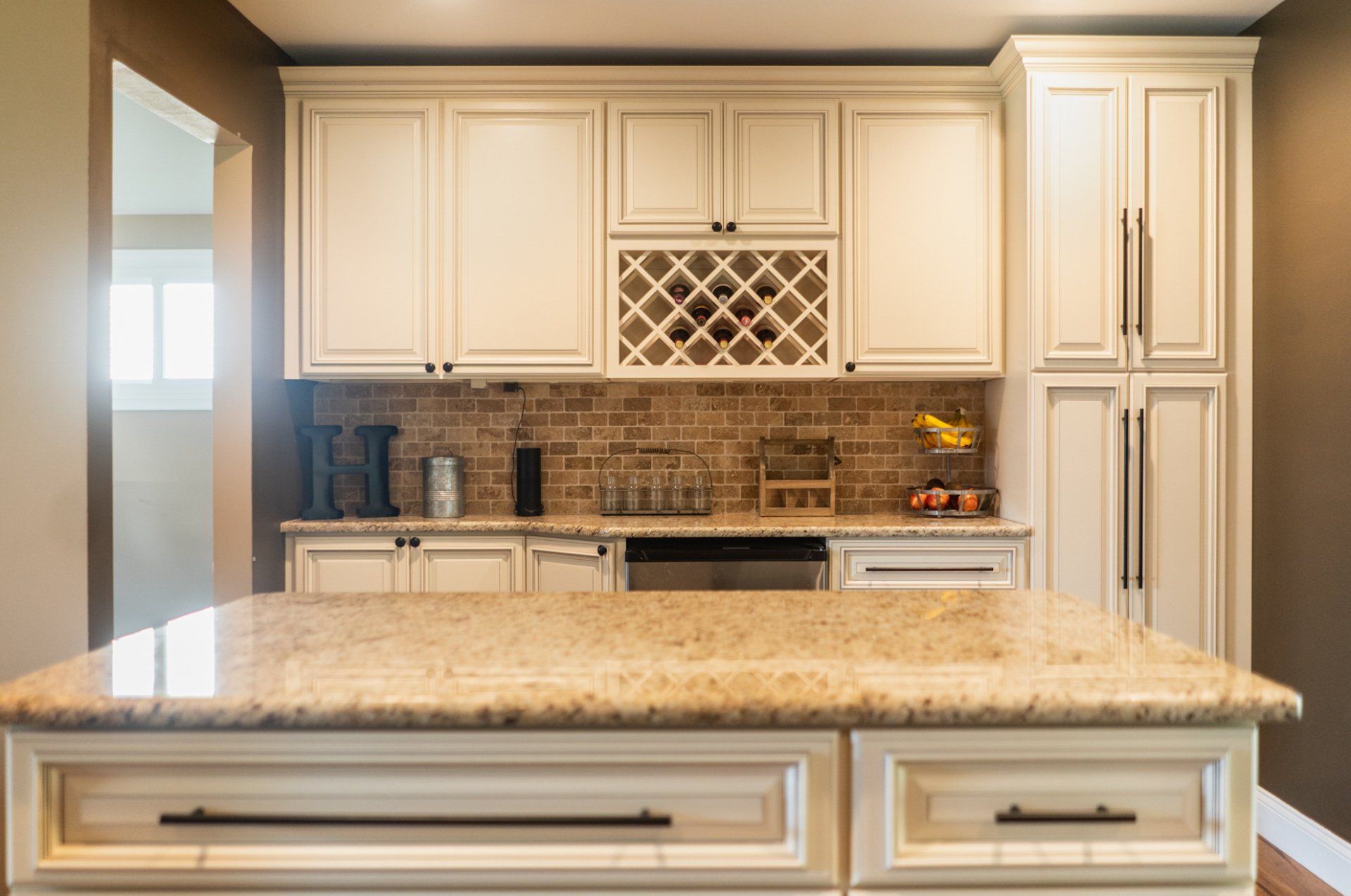 kitchen remodel with new white cabinets and brown backsplash