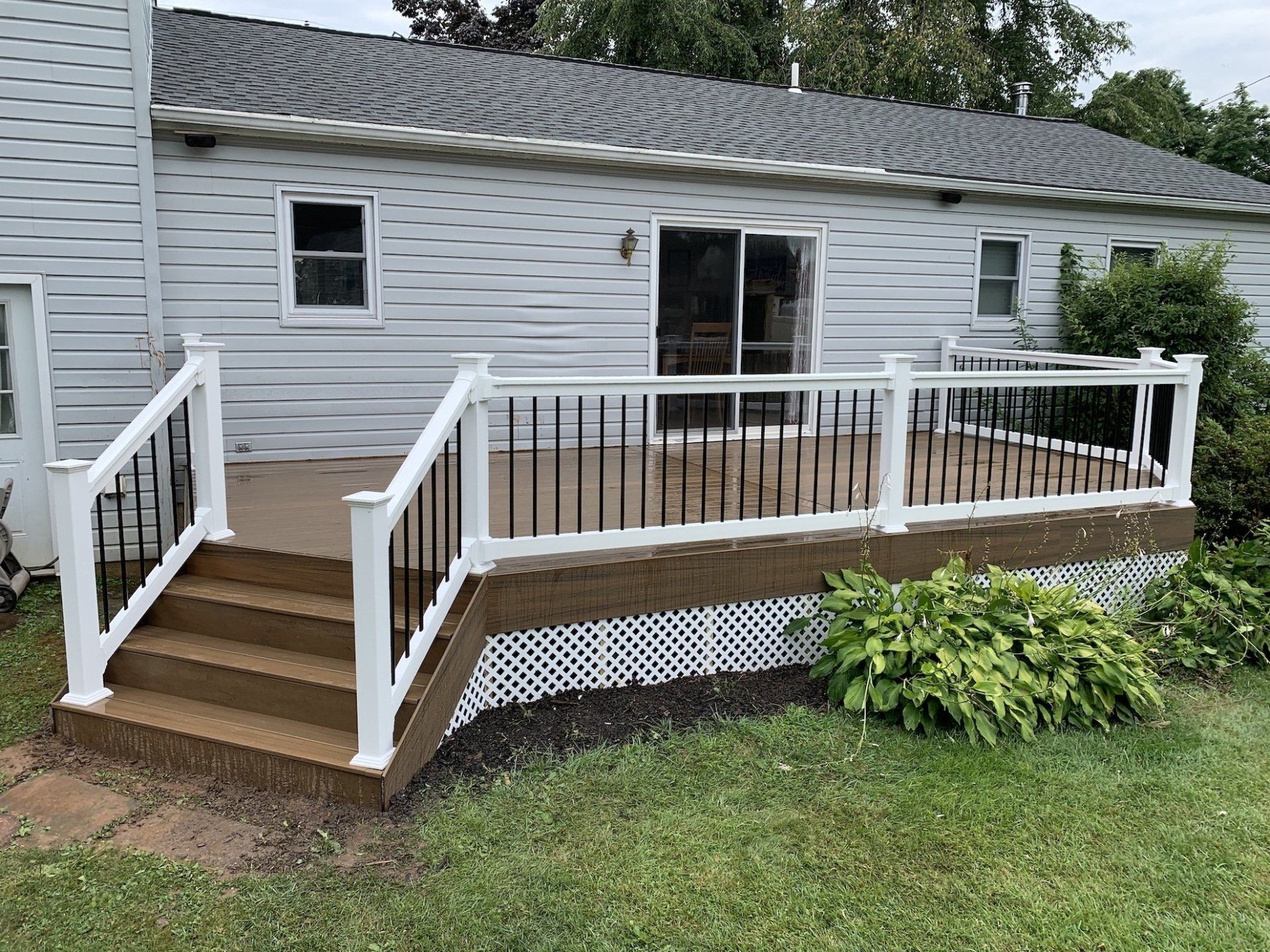 backyard view of large new deck with railings and steps