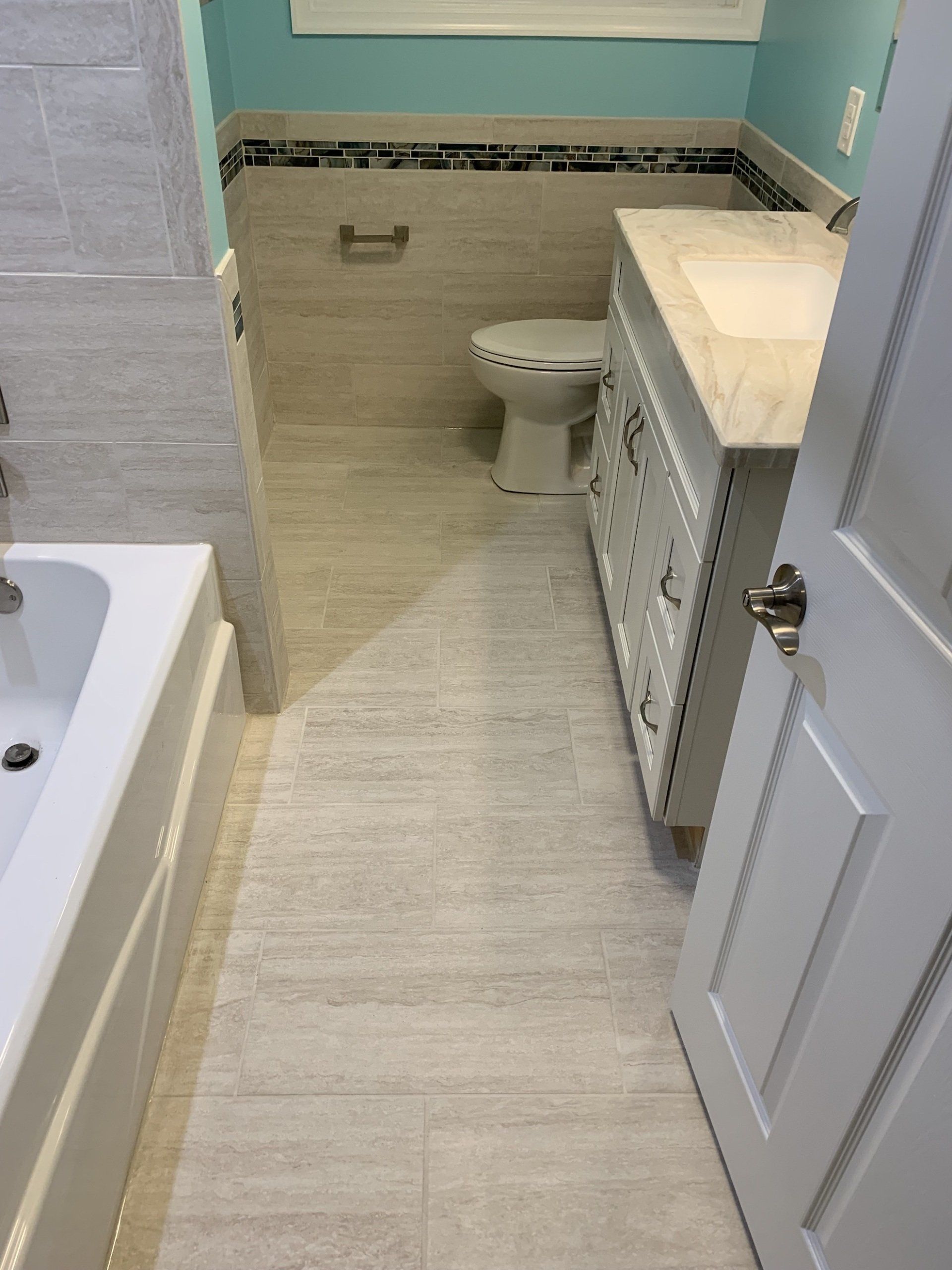 bathroom renovation adding new floors, accent tile around bathroom walls