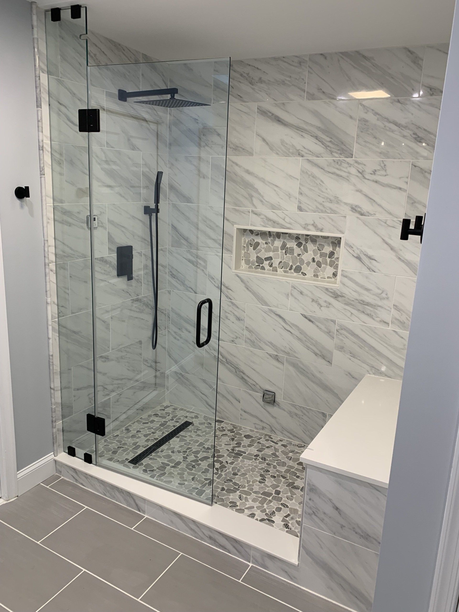 walk in shower area renovation adding floor tile, tile on walls bench seat with sliding glass door