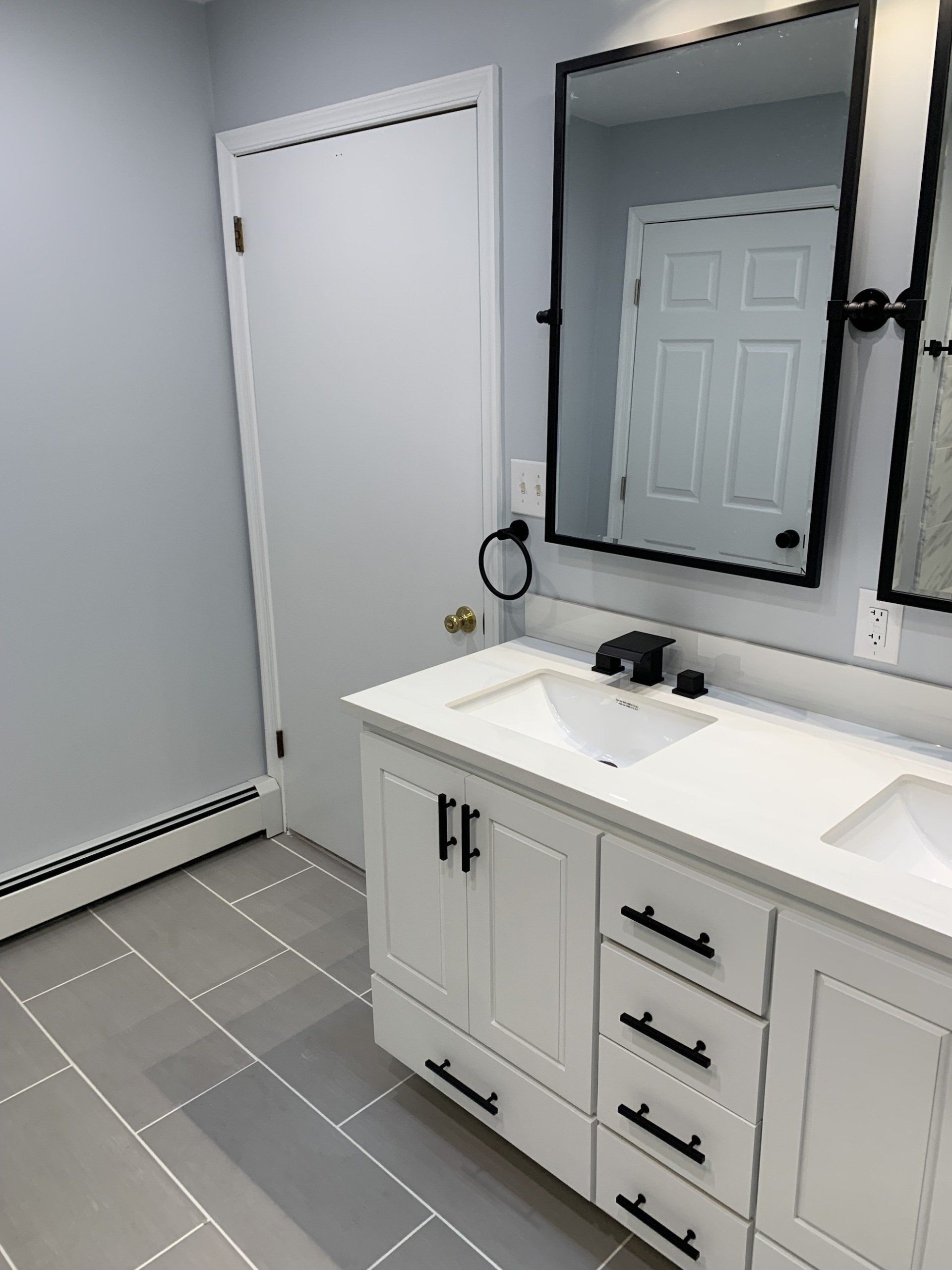 bathroom renovation with double mirrors white cabinets