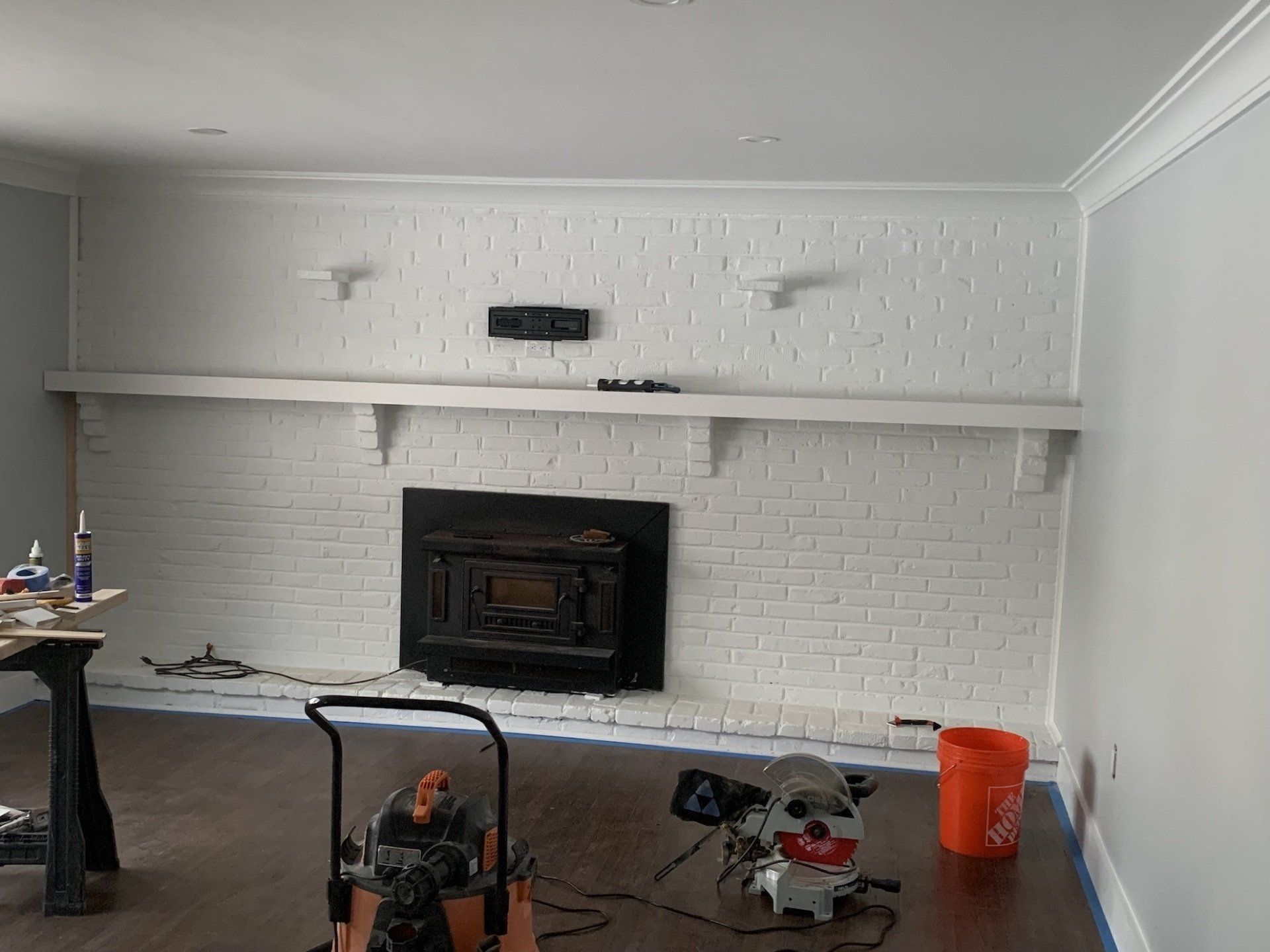 Basement renovation with fireplace and white painted brick