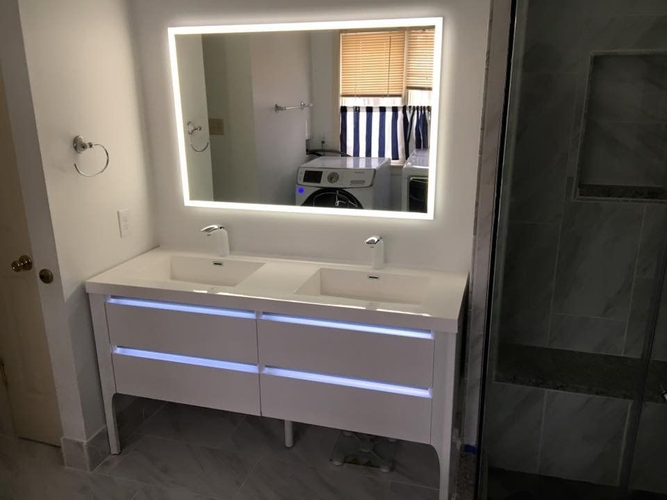 remodeled bathroom with silver accent and lighted mirror