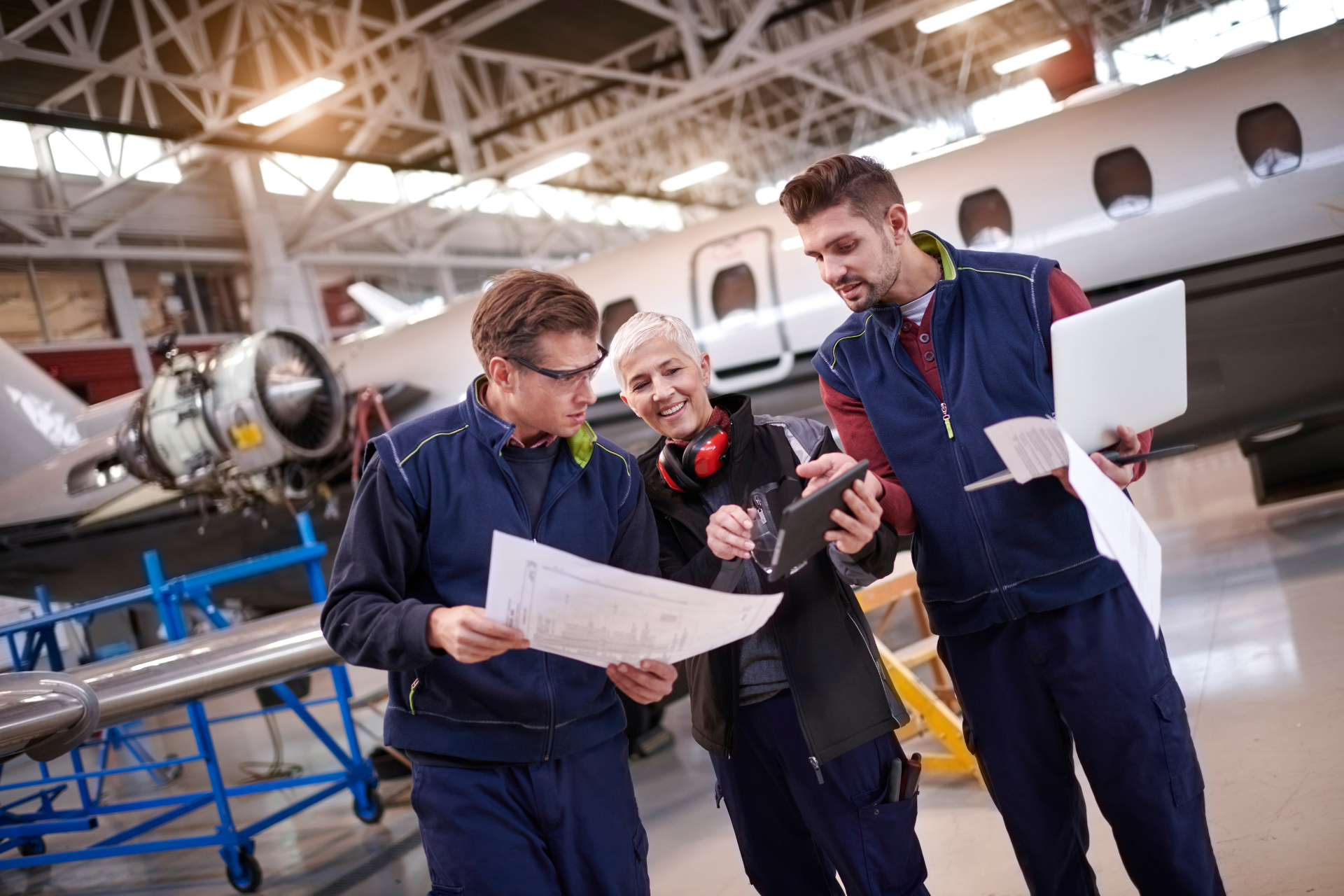A group of people are working on an airplane in a hangar.