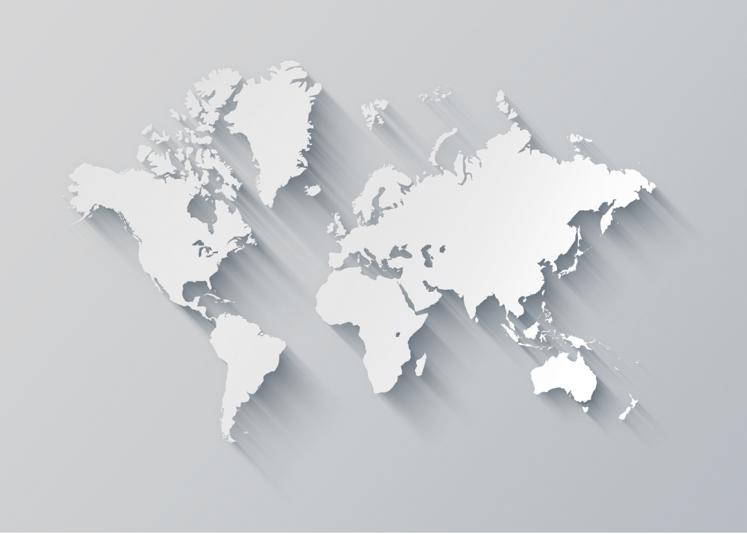 A white map of the world with a long shadow on a gray background.