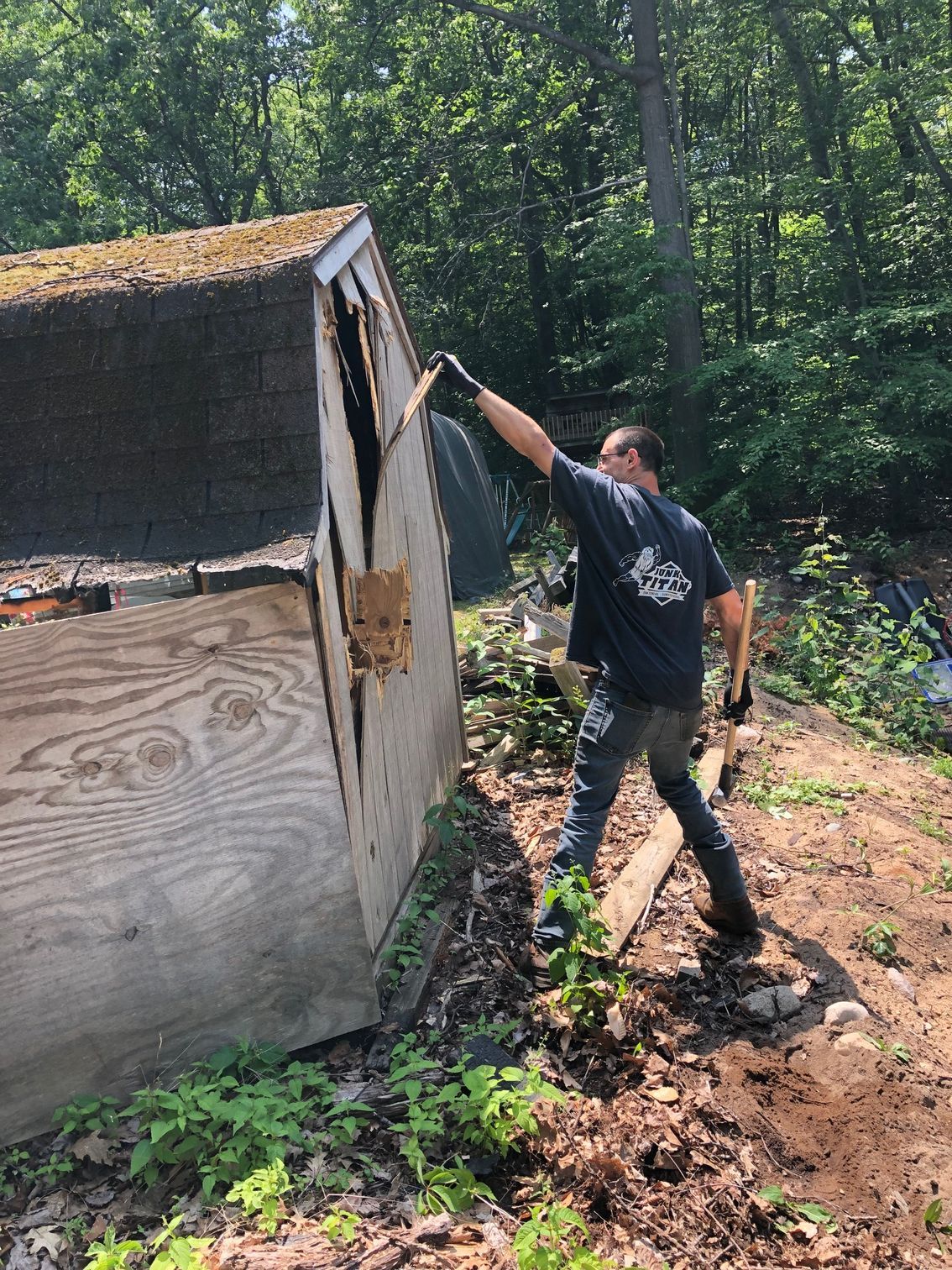 man demolishing shed with tools