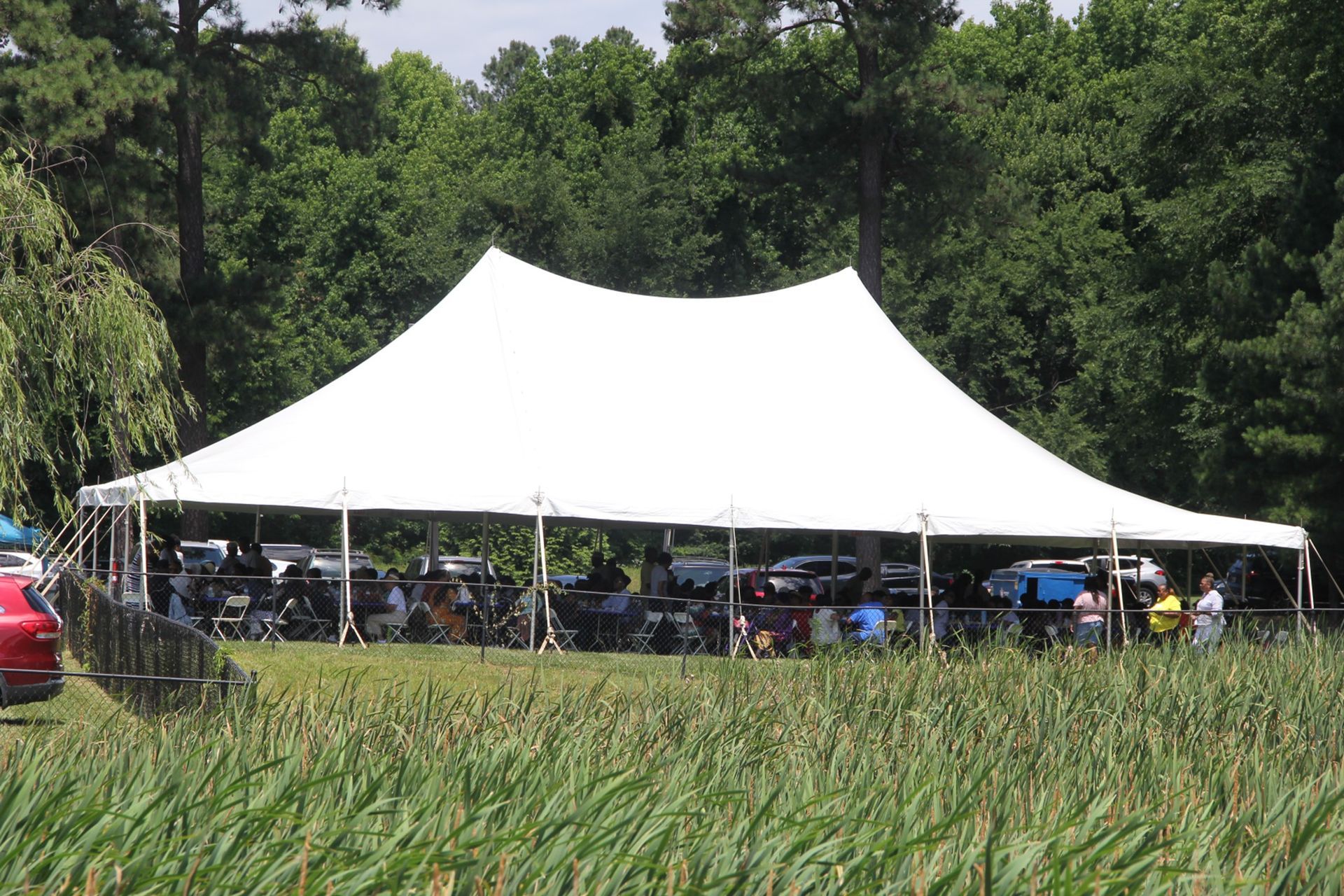 A large white tent is sitting in the middle of a field.