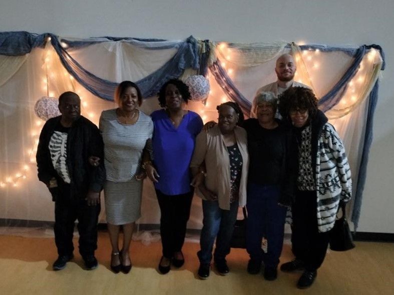 A group of people standing in front of a wall with lights