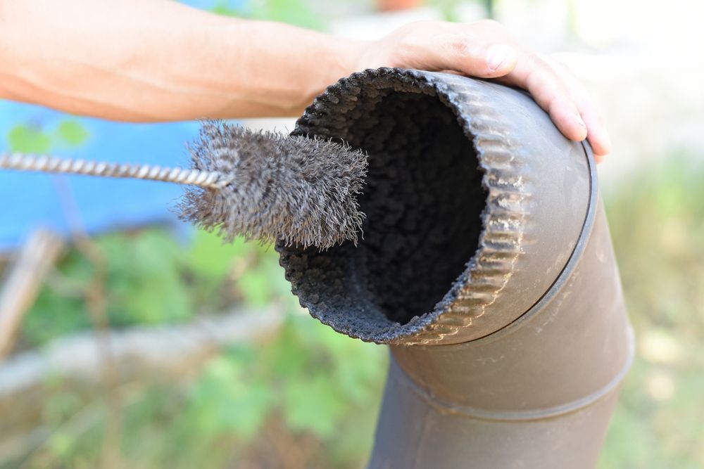 A person is cleaning a chimney with a brush.