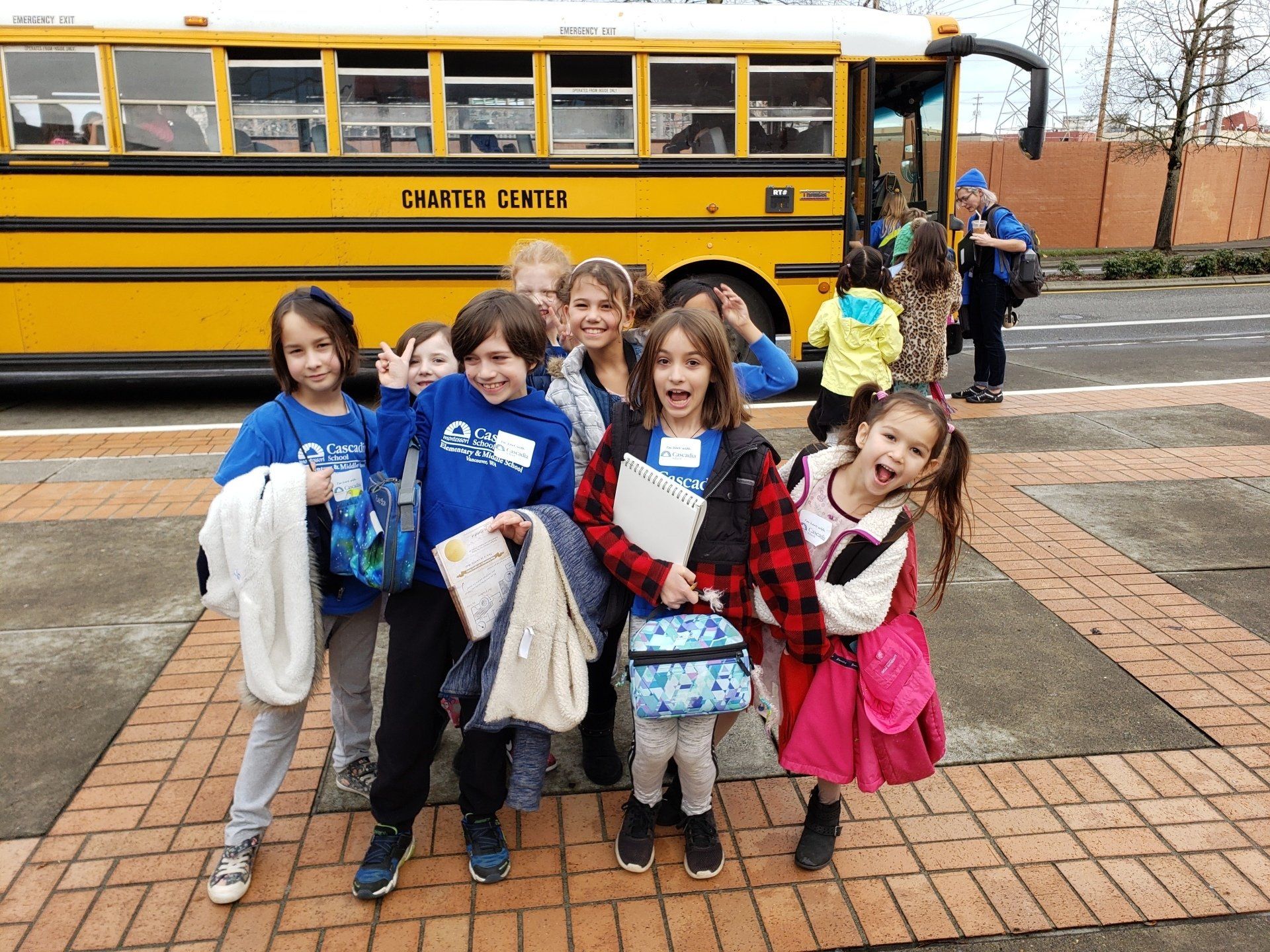 A group of children are posing for a picture in front of a school bus.