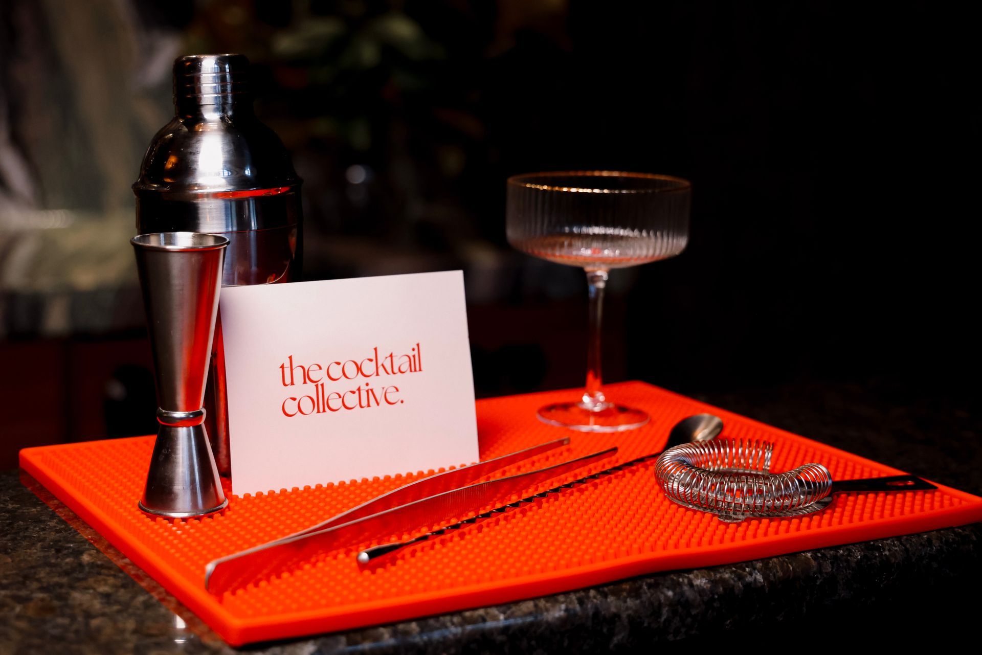 An orange mat with a card that says the cocktail club on it