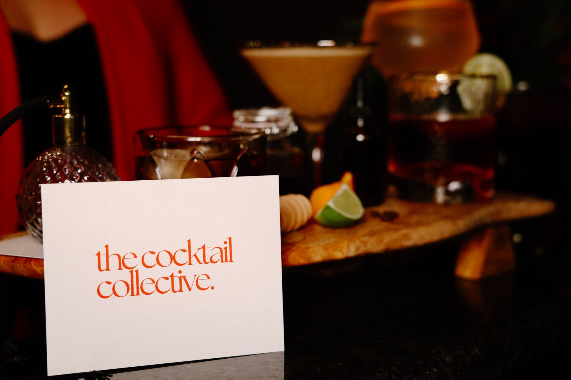 A sign that says the cocktail collective is sitting on a table.