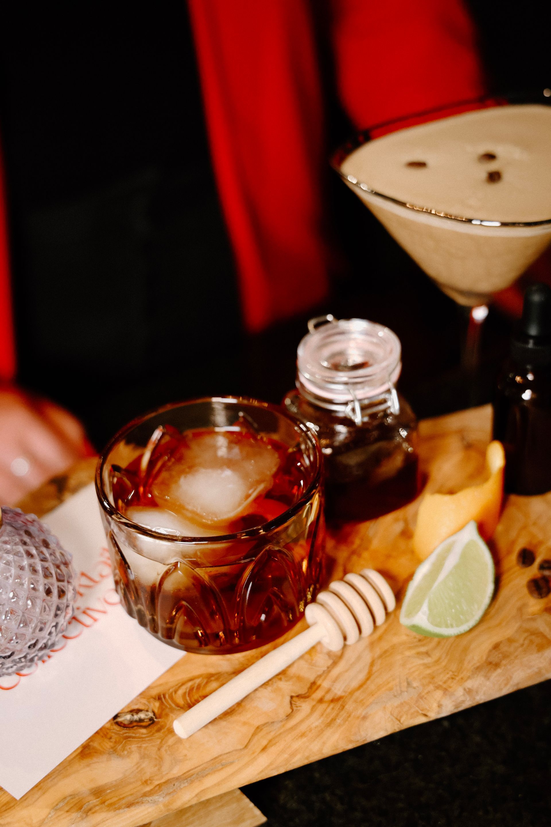 A person is preparing a drink on a wooden cutting board.