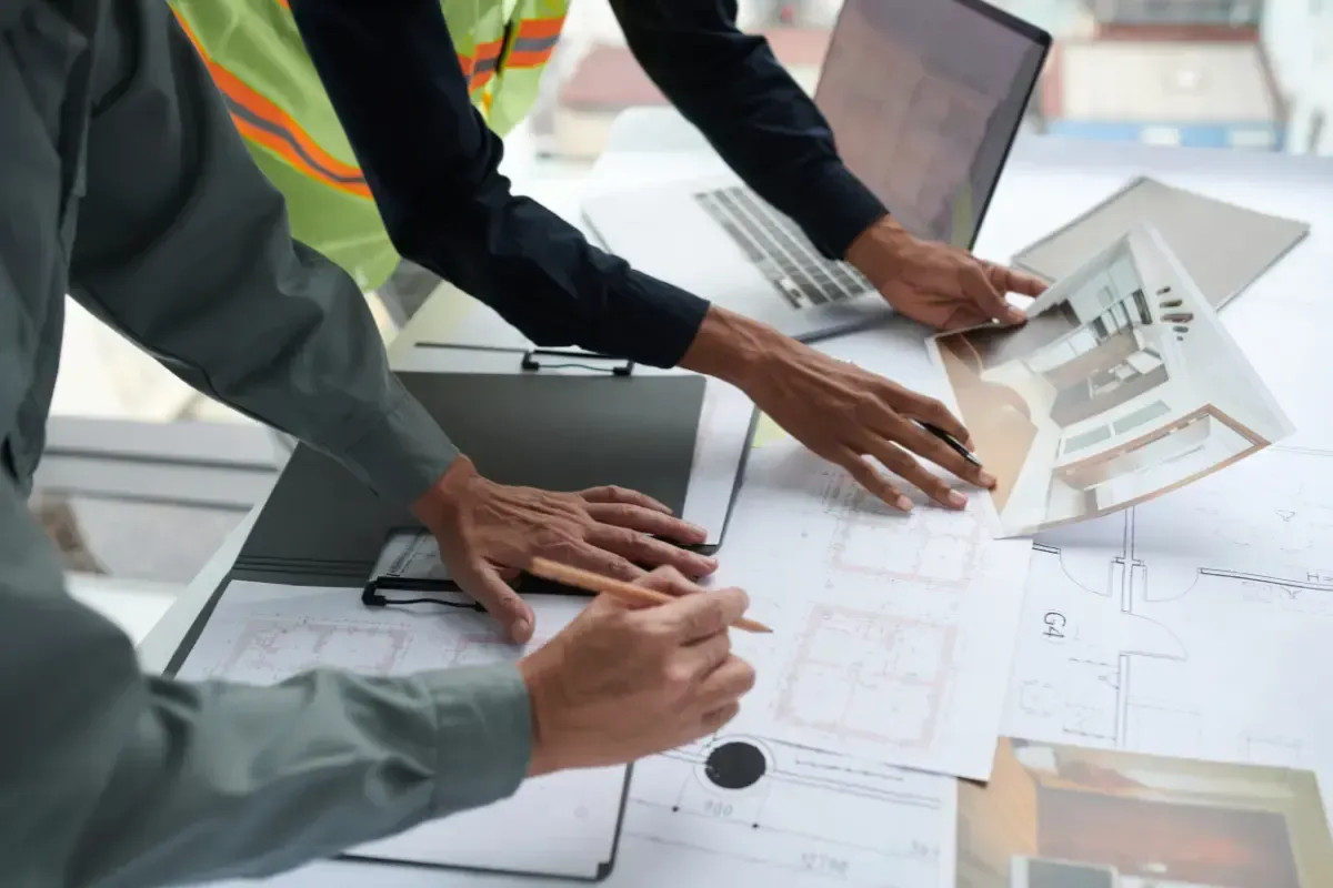 Two builders planning home renovation while checking blueprints