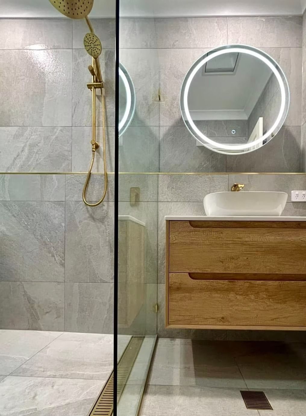A bathroom with a walk in shower , sink and mirror.