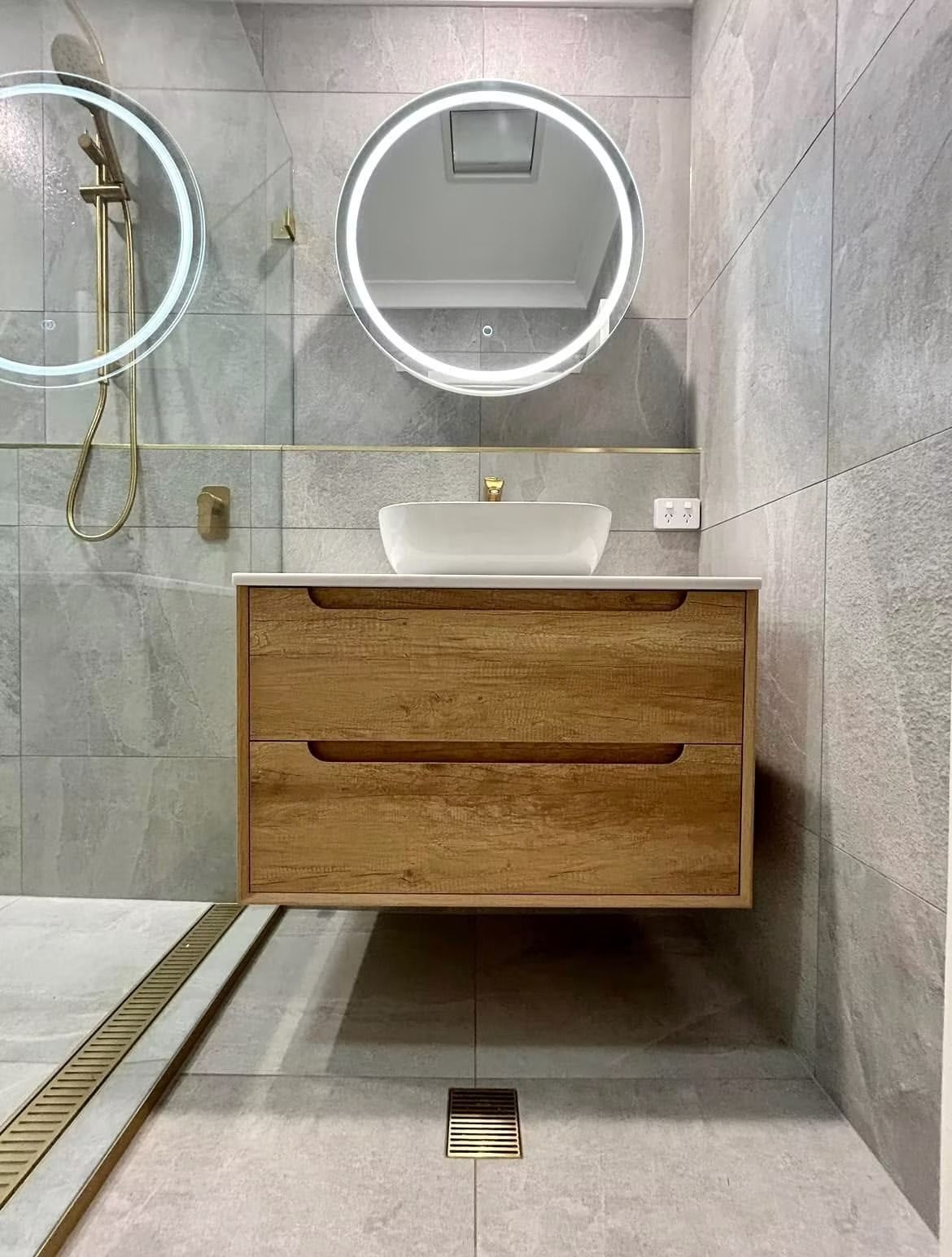A bathroom with a sink , mirror and shower.