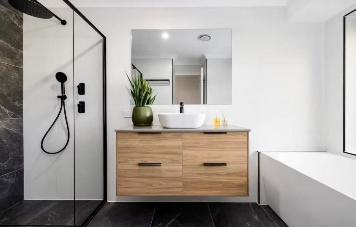 A bathroom with a sink , mirror and shower.