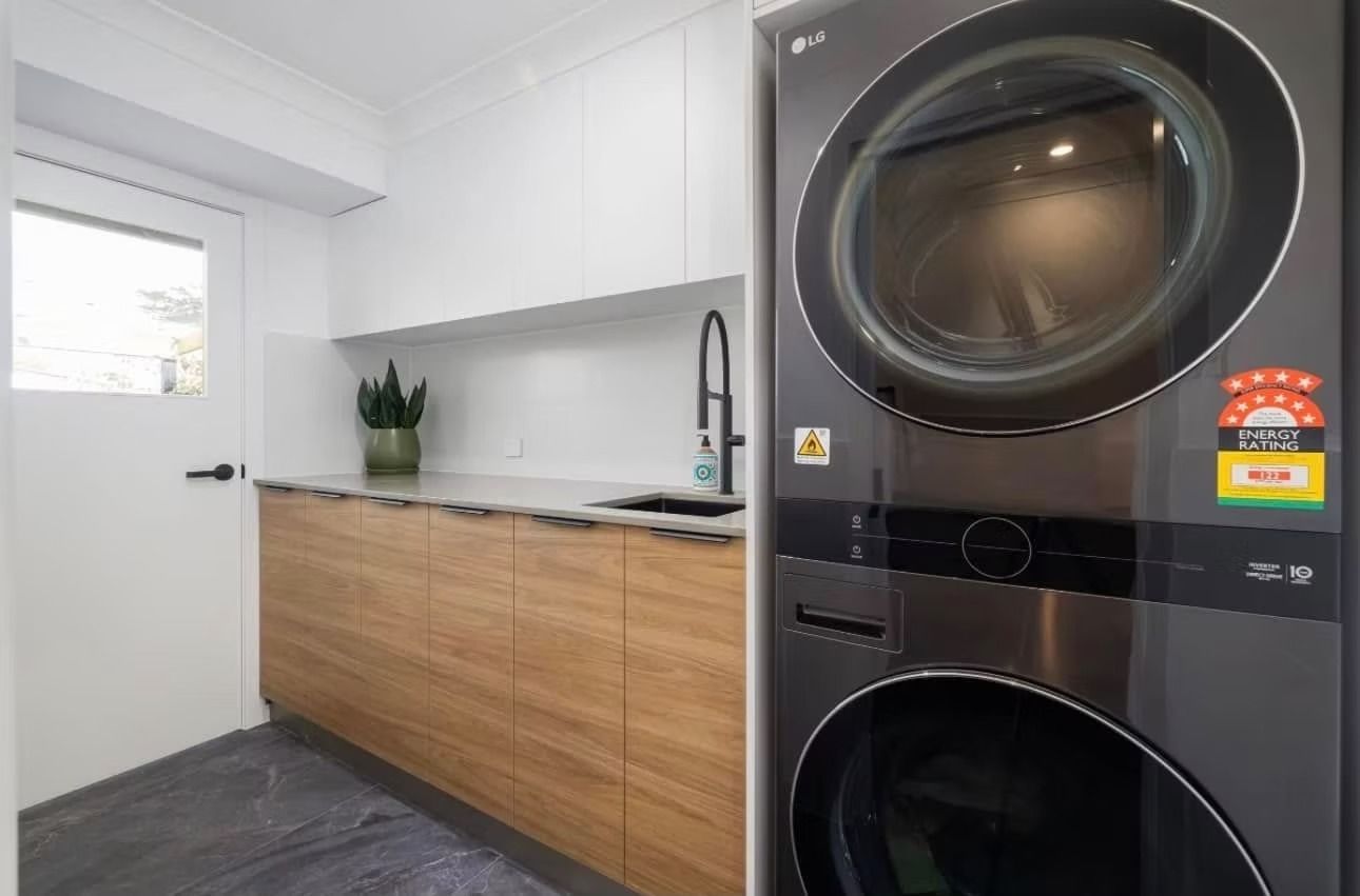 A laundry room with a washer and dryer stacked on top of each other.