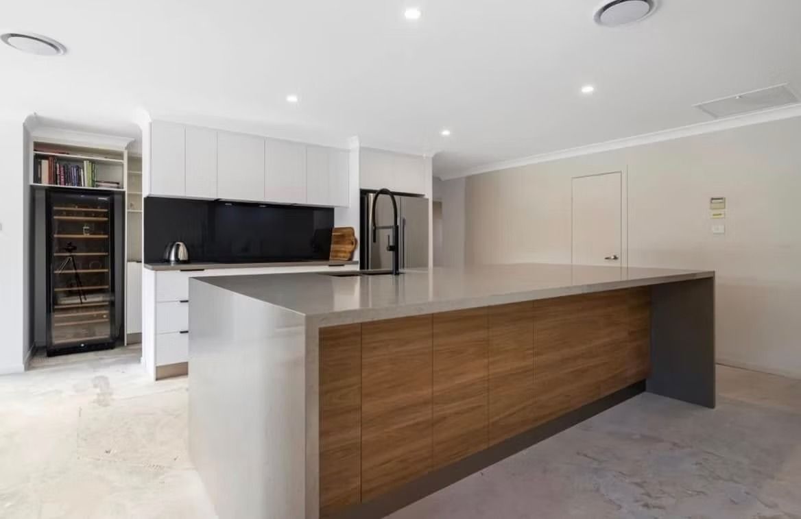 A kitchen with a large island and a refrigerator.