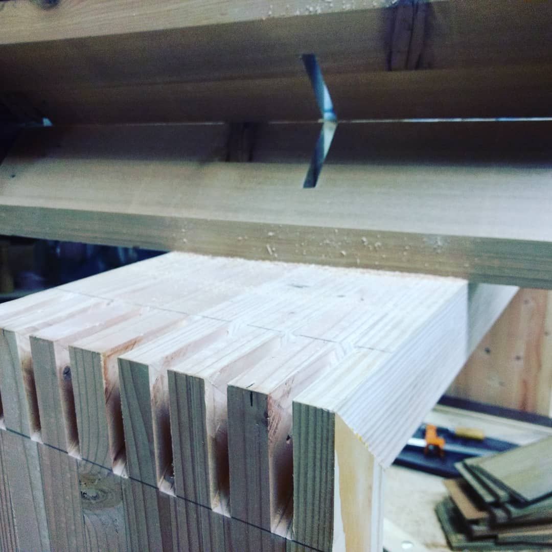 Wooden dovetail joints being cut with a saw, woodworking project.