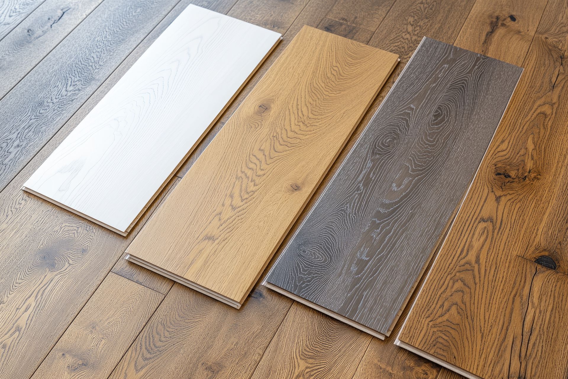 Three different types of wooden flooring are sitting on a wooden floor.