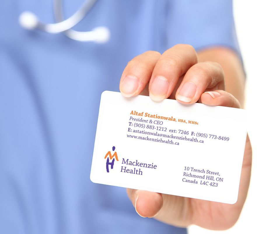 Doctor holding Mackenzie Health business card