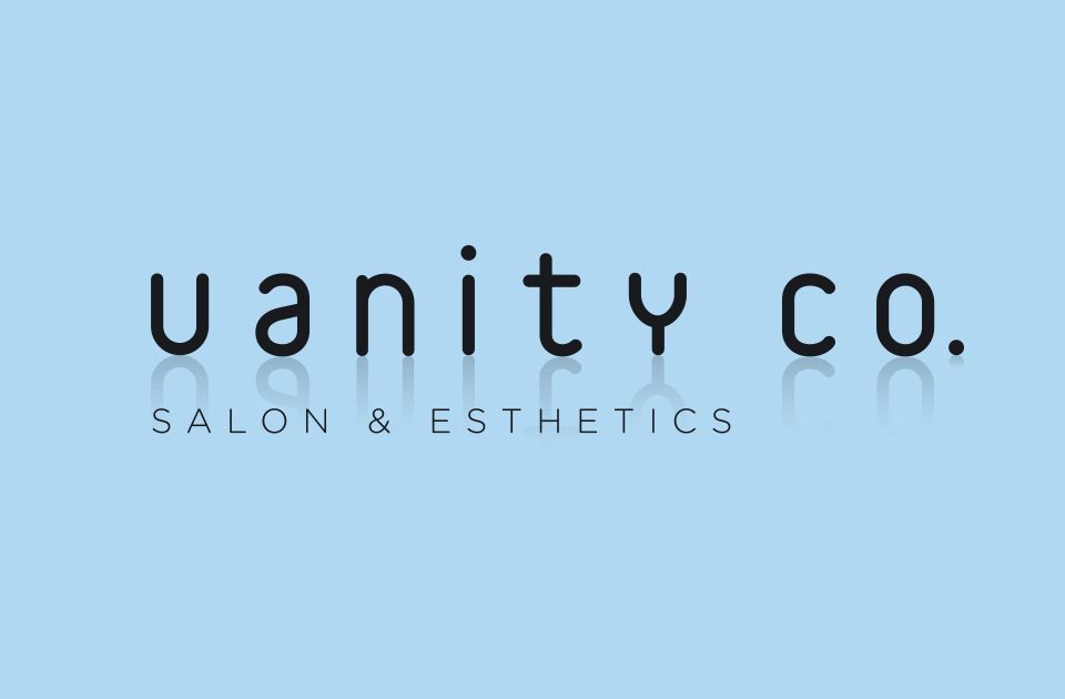 A vanity co. salon and cosmetics logo on a blue background