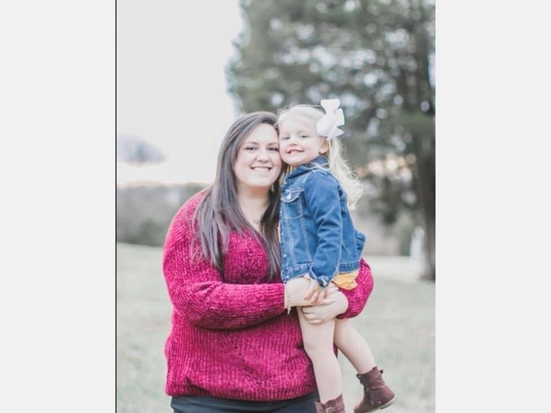 A woman is holding a little girl in her arms.