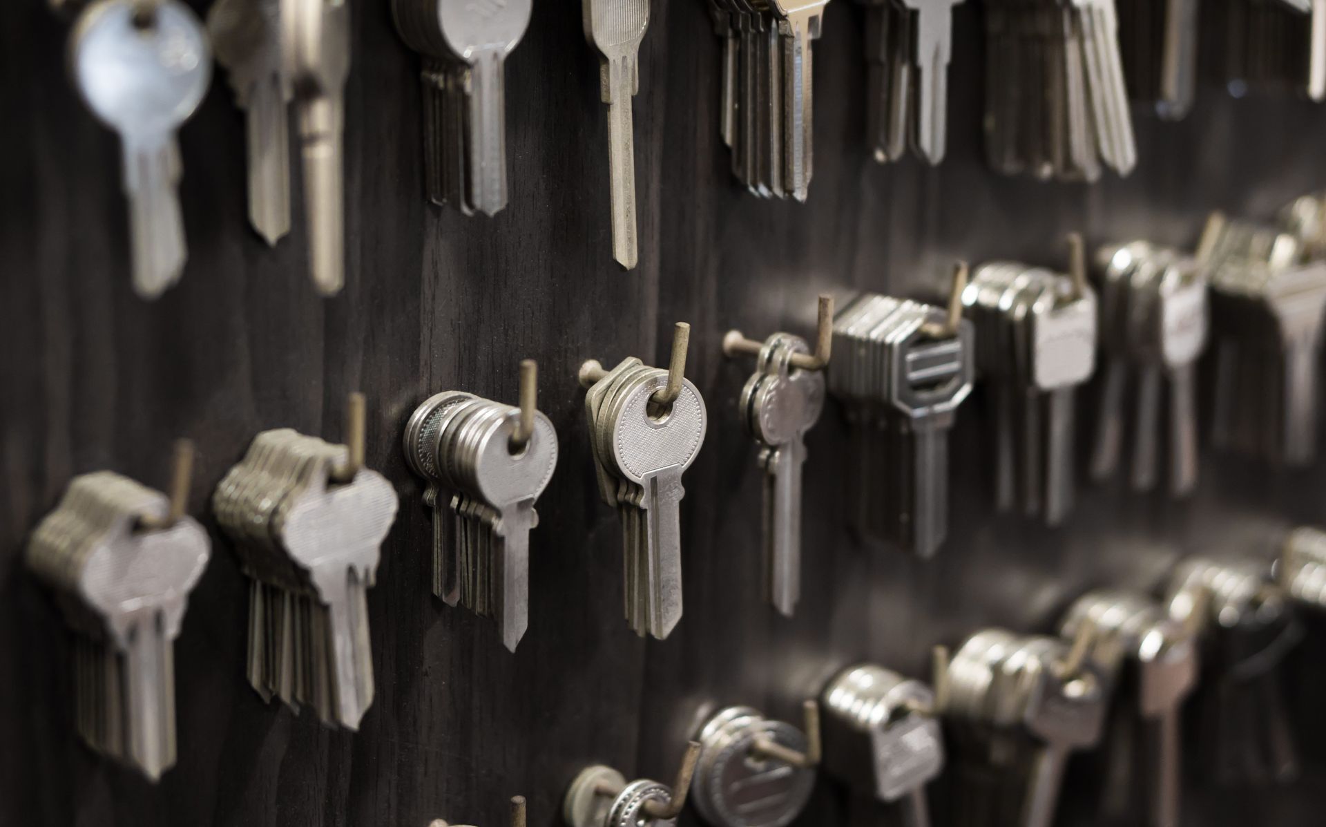 a bunch of keys are hanging on a wall