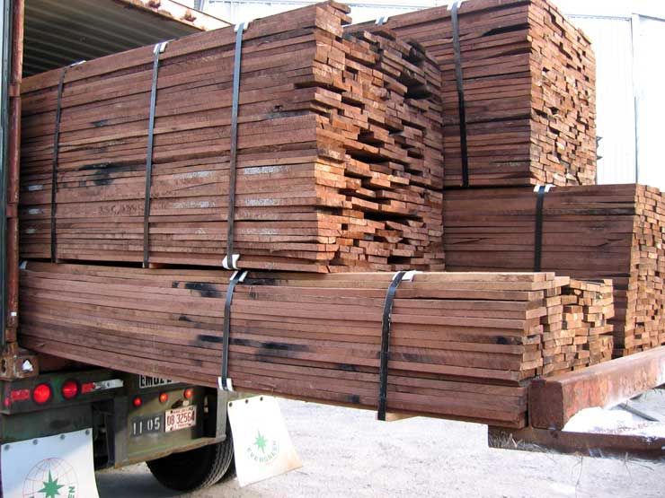 A truck is loaded with a stack of wood boards