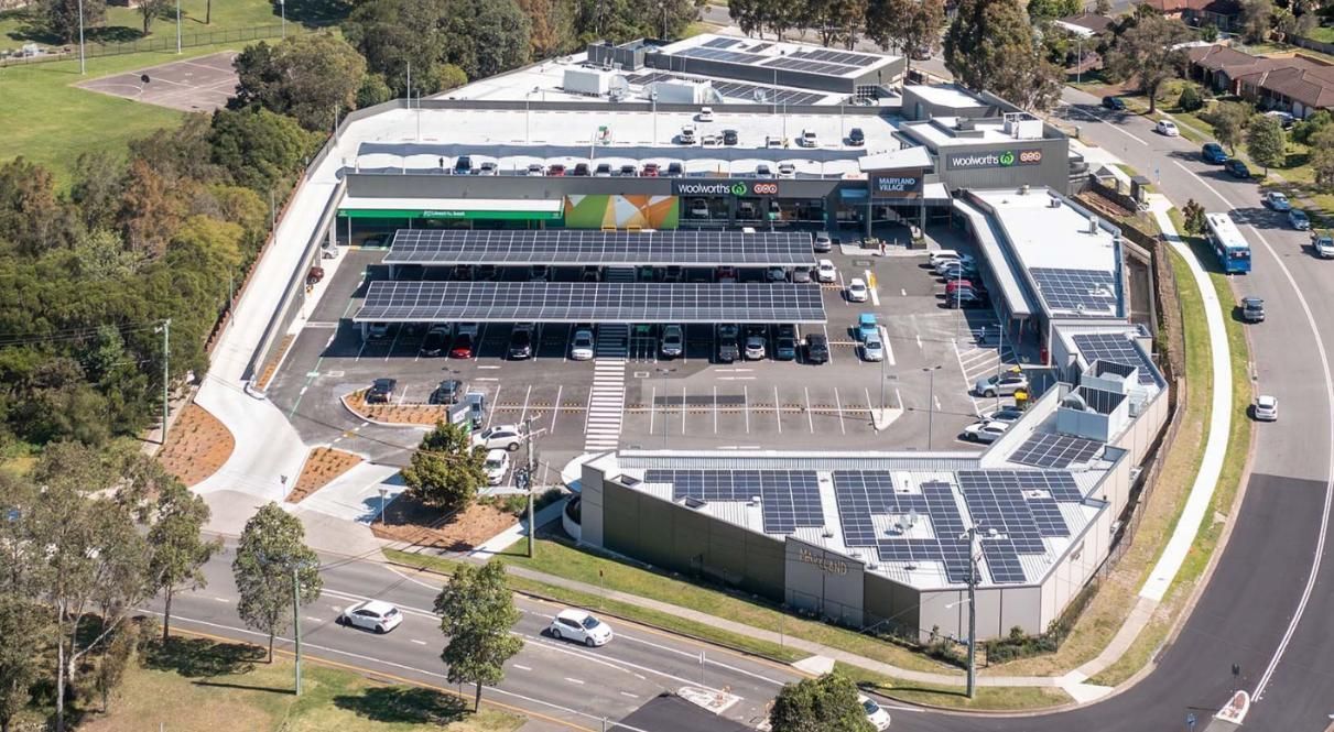 An Aerial View of A Large Building with Solar Panels on The Roof — Duggan Mather Surveyors in Taylors Beach, NSW
