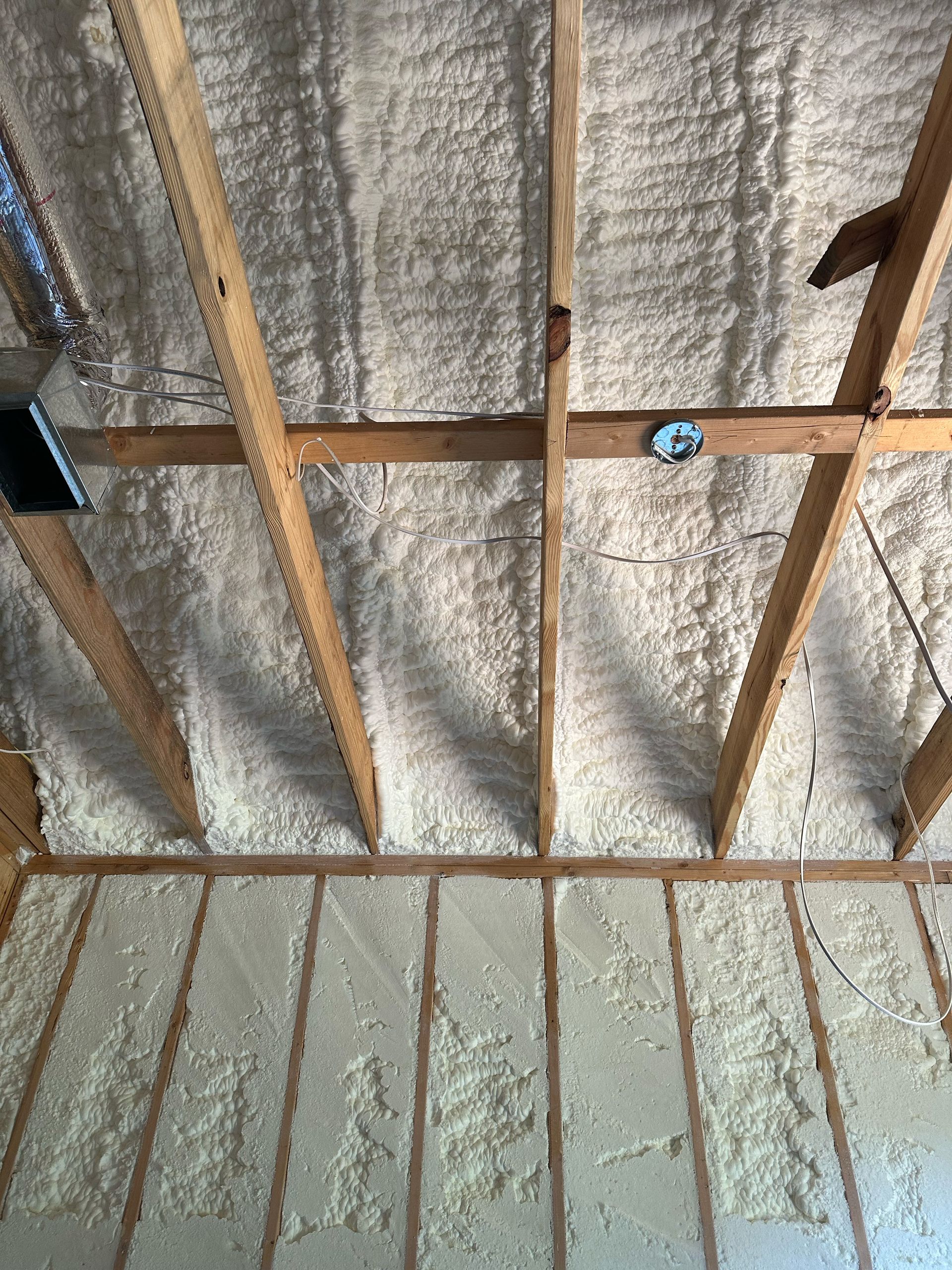 The ceiling of a house is covered in spray foam.
