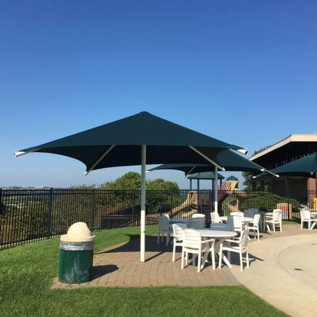 A patio area with tables and chairs under umbrellas.